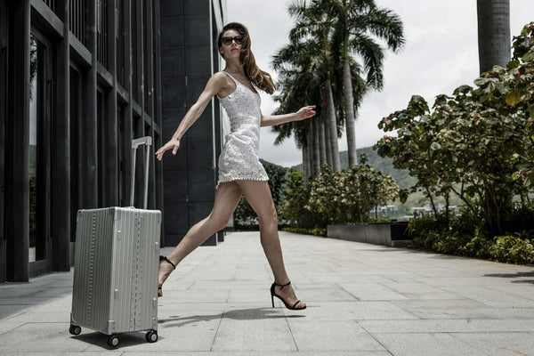 WOmen wheeling a suit case on 4 wheels with ease