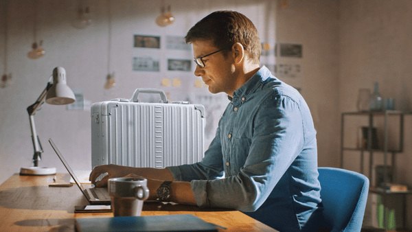 Briefcase at desk and man working from home luggage for men