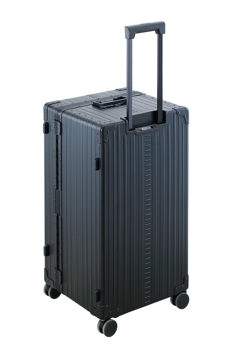 Sleek Onyx Black Aluminum Trunk – Durable 30-inch Checked Luggage|A close-up of the onyx suitcase’s high-density double quad wheels, designed for smooth 360-degree rotation. The aluminum side handle is visible, offering an alternative carrying option for convenience.|The black suitcase is fully opened, revealing a spacious interior with a fitted packing cube and a compression panel designed to kee