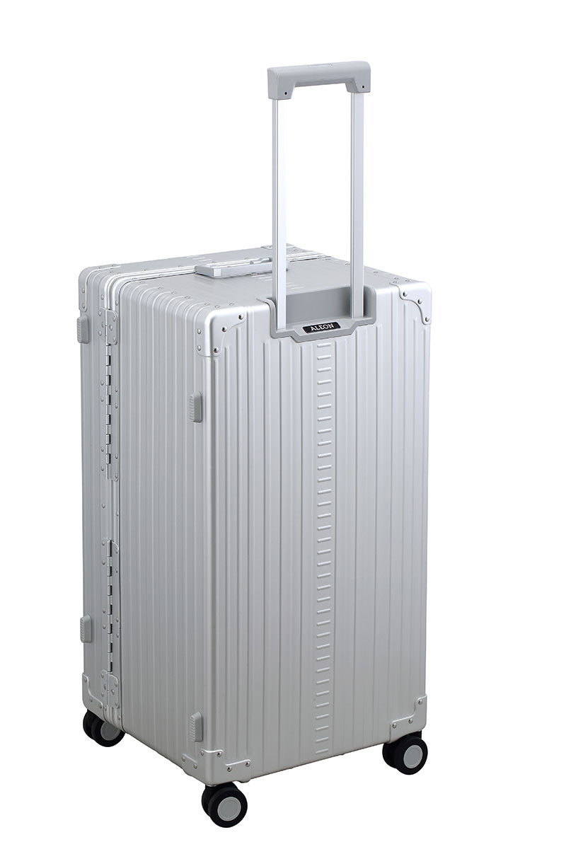 Silver Platinum 30-inch Aluminum Trunk – International Checked Spinner Case|A close-up of the silver suitcase’s high-density double quad wheels, designed for smooth 360-degree rotation. The aluminum side handle is visible, offering an alternative carrying option for convenience.|The platinum suitcase is fully opened, revealing a spacious interior with a fitted packing cube and a compression panel 