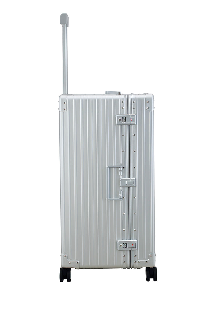 Silver Platinum 30-inch Aluminum Trunk – International Checked Spinner Case|A close-up of the silver suitcase’s high-density double quad wheels, designed for smooth 360-degree rotation. The aluminum side handle is visible, offering an alternative carrying option for convenience.|The platinum suitcase is fully opened, revealing a spacious interior with a fitted packing cube and a compression panel 