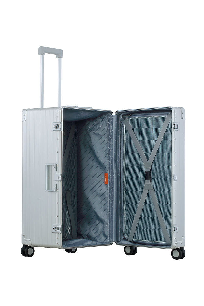 Silver Platinum 30-inch Aluminum Trunk – International Checked Spinner Case|A close-up of the silver suitcase’s high-density double quad wheels, designed for smooth 360-degree rotation. The aluminum side handle is visible, offering an alternative carrying option for convenience.|The platinum suitcase is fully opened, revealing a spacious interior with a fitted packing cube and a compression panel 