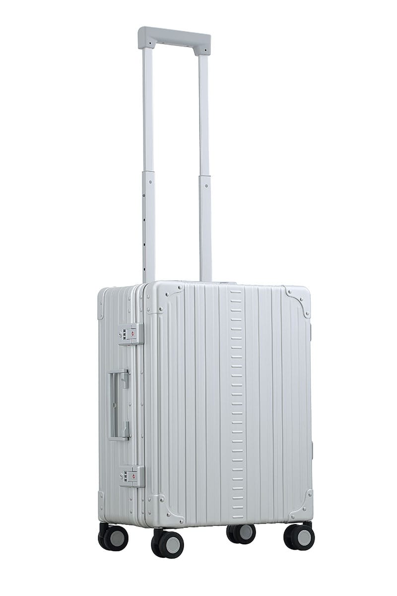 Aleon carry on with suiter in platinum color|Side view of Aleon carryon with suiter in silver|ALEON silver Carry-On with Suiter open to reveal a thoughtfully designed interior, featuring compression straps, a zippered divider, and a fold-out suiter for wrinkle-free garment storage.|Lock view of Aleon carry on equipped with TSA approved locks|26 inch aluminum checked suitcase with wheels||silver ch