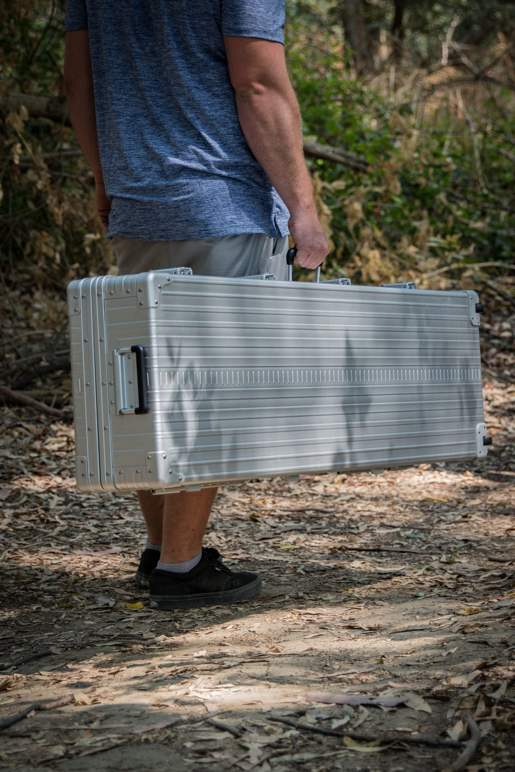 Aleon 52-inch aluminum long case carried by handle, showing durable hard‑shell construction for secure transport.
