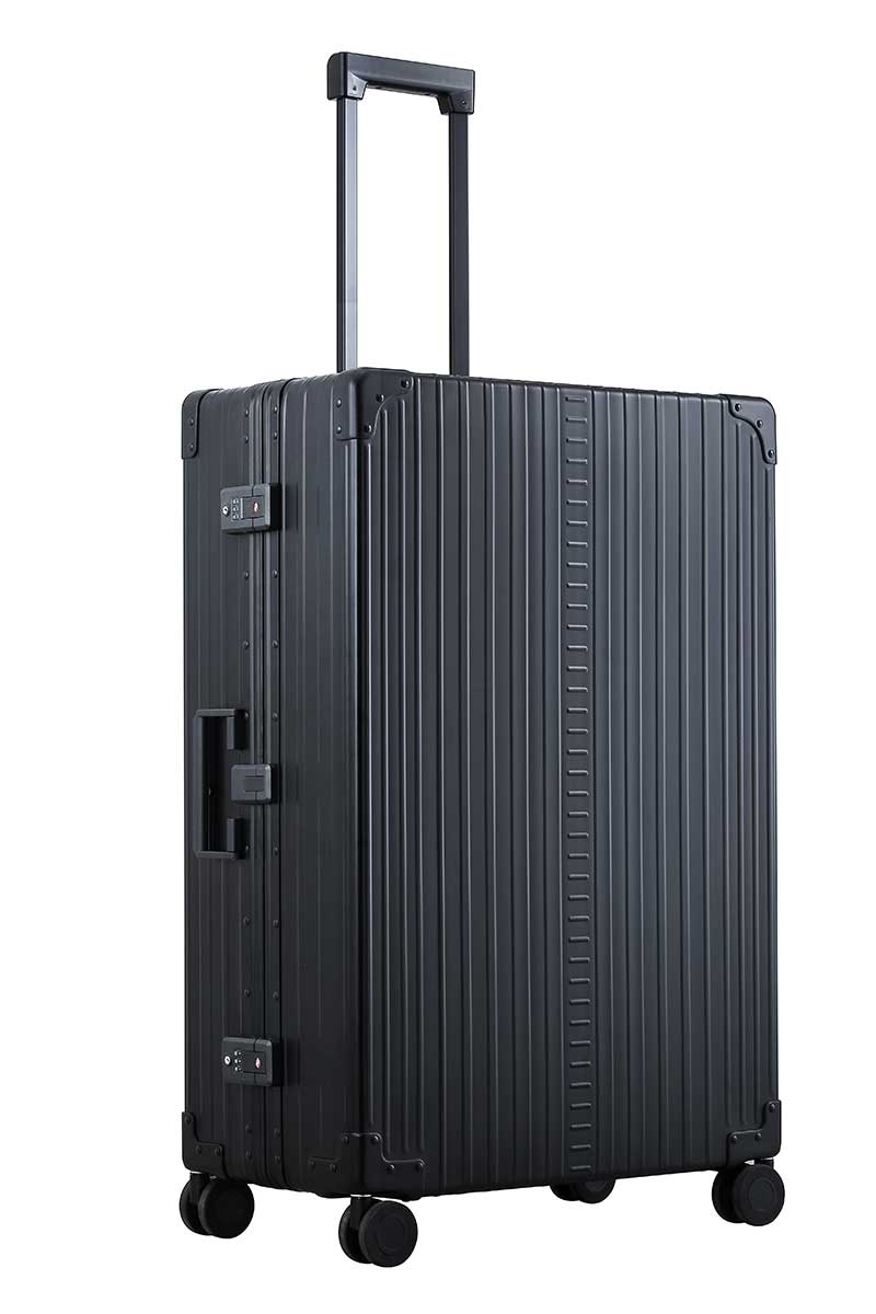 Black-32-inch-aluimunm-checked-bag|The black onyx ALEON 32″ Macro Plus glides smoothly through an airport terminal, its high-performance wheels designed for quiet and stable movement. The ergonomic telescoping handle ensures comfortable handling, even in bustling travel environments.|The ALEON 32″ black Macro Plus glides smoothly through an airport terminal, its high-performance wheels designed fo