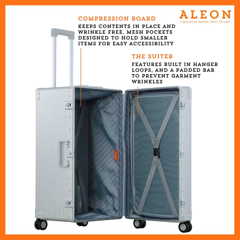 The platinum suitcase is fully opened, revealing a spacious interior with a fitted packing cube and a compression panel designed to keep belongings secure and wrinkle-free. The seamless rubber seal lining ensures protection against moisture and dust.