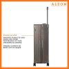 The ALEON 32″ bronze Macro Plus Traveler, with its brushed aluminum finish, leans against a baggage claim carousel. Its sleek exterior catches ambient lighting, showcasing its premium craftsmanship and refined design built for sophisticated travelers.