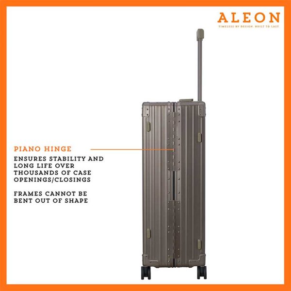 The ALEON 32″ bronze Macro Plus Traveler, with its brushed aluminum finish, leans against a baggage claim carousel. Its sleek exterior catches ambient lighting, showcasing its premium craftsmanship and refined design built for sophisticated travelers.