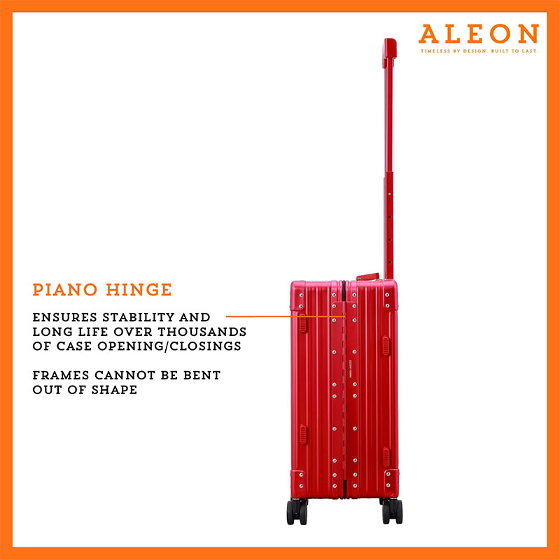 A polished red ruby aluminum ALEON 21" Carry-On stands upright on a glossy airport floor, reflecting ambient lighting. Its durable, hard-shell construction and smooth wheels embody modern travel efficiency.