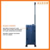 The ALEON 21" blue sapphire Carry-On rests beside a plush airport lounge chair, its refined metallic finish complementing the sophisticated travel setting. Designed for durability and elegance, it exudes premium craftsmanship and functionality.