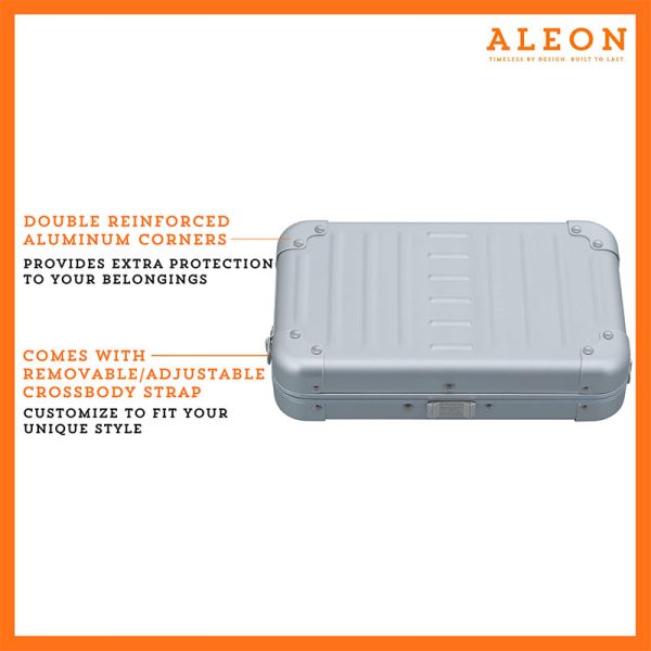 ALEON platinum silver crossbody case displayed with highlighted features, including double reinforced aluminum corners for enhanced durability and an aluminum clasp for secure closure. The case is open, revealing organized interior compartments. Brand name 'ALEON' and tagline 'TIMELESS BY DESIGN. BUILT TO LAST.' are shown at the top right.